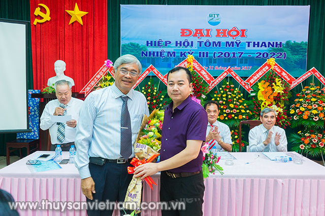 TS Trần Định Luân, Phó Tổng cục Trưởng Tổng cục Thủy sản tặng hoa cho ông Võ Quan Huy, Chủ tịch Hiệp hội Tôm Mỹ Thanh nhiệm kỳ III