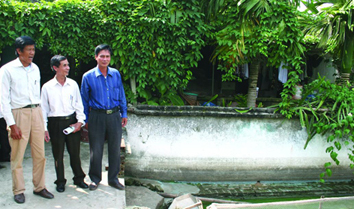 Ông Nguyễn Quang Trung (phải) - Bí thư Đảng ủy xã Phú Điền (huyện Nam Sách) giới thiệu mô hình nuôi cá của mình với Chủ tịch HNC huyện Nam Sách, ông Trần Văn Đương (giữa)